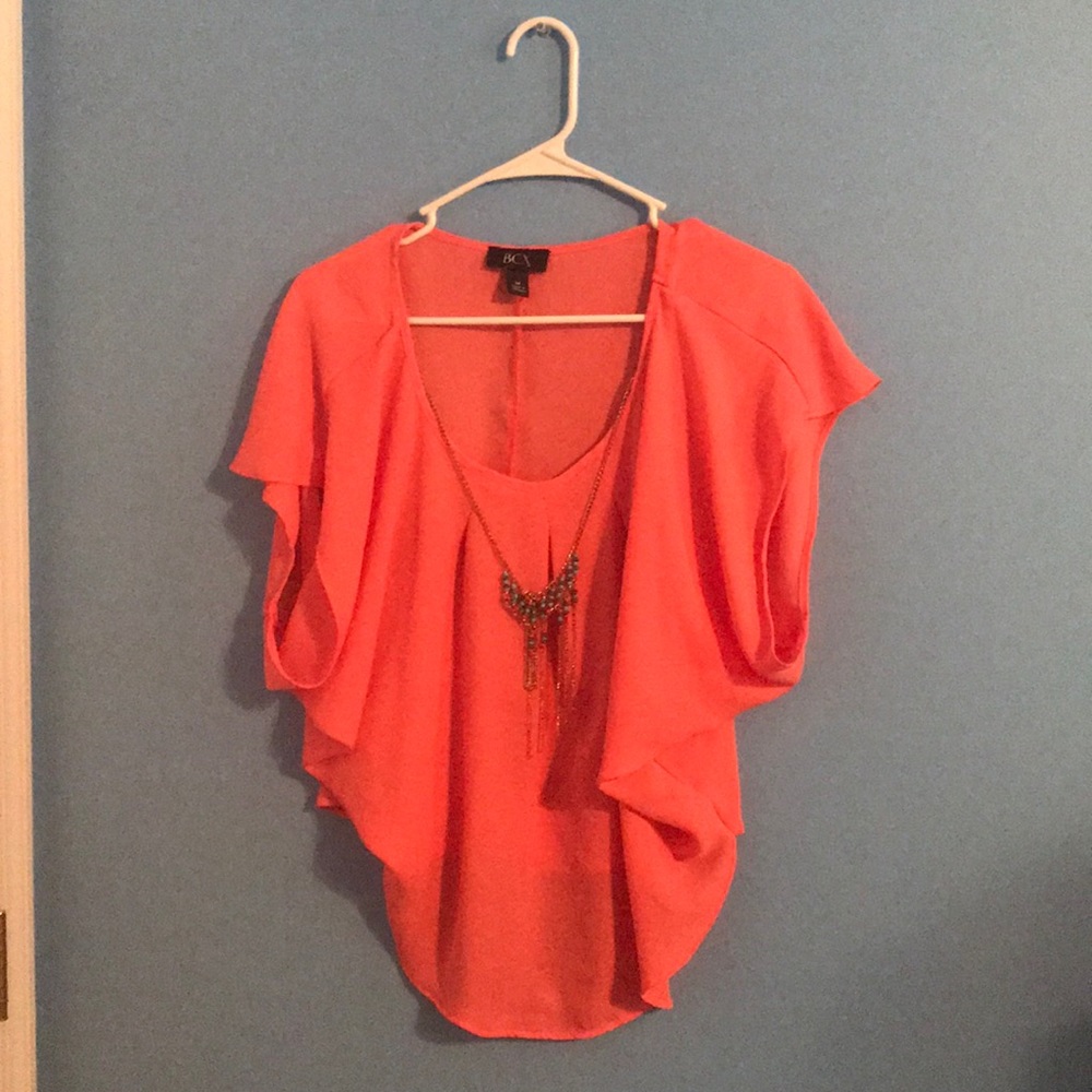 Coral shirt with necklace.